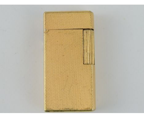 A Dunhill 'Rollagas' gold plated lighter, rectangular with an engine turned finish, H. 6cm.