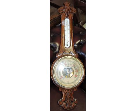 An early 20th century aneroid barometer, carved oak frame incorporating a thermometer, H. 82cm; together with a wall clock. (