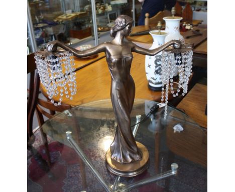 An Art Deco style bronzed metal table lamp modelled as an elegant lady holding two beaded petal shades, H. 62cm.