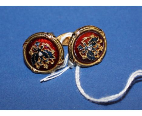 A pair of Russian enamelled silver gilt cufflinks decorated with twin head eagle motifs.