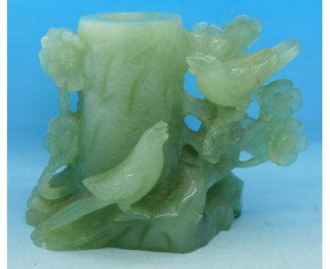 A carved jade coloured figure of two birds at a tree trunk, 11.5cm