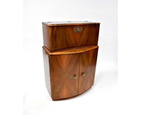 An Art Deco walnut veneered cocktail cabinet with front lift-up and drop-down cabinet with mirrored back, base and door, the 