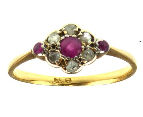 A late 19th/early 20th century 18ct gold ruby and diamond flower head ring, the central ruby in a circle of six rose cut ston