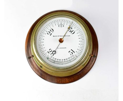 A Kelvin Bottomley &amp; Baird Ltd of Glasgow brass ship's barometer mounted on a wooden base, diameter 14.5cm.
