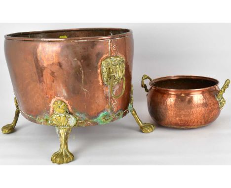 A large brass and copper coal bucket of oval shape, with lion mask and hoop handles, raised on four lion paw feet, height 31c