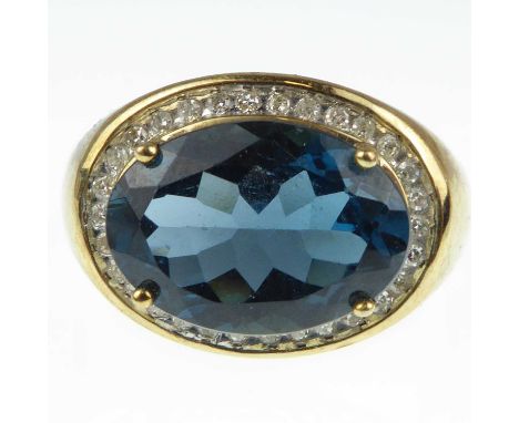 A 9ct gold diamond and blue stone ring with oval cut claw set blue stone in a border of tiny diamond chips, size Q/R, approx.