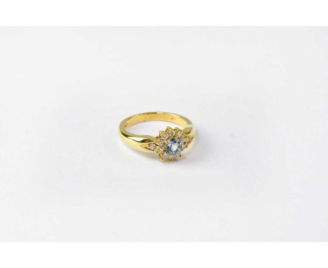 An 18ct gold cluster ring set with topaz and diamonds, stamped 750, size N, approx. 5.7g.Condition Report: Topaz appears dull