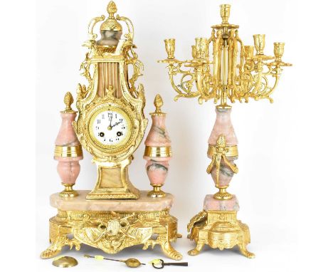 A 20th century French striking mantel clock, the gilt metal body in the form of a lyre with eagle finials, on pink marble bas