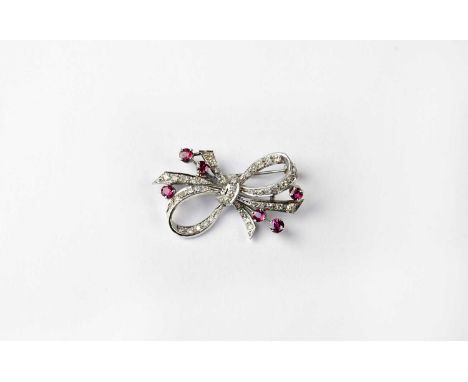 A white metal diamond and ruby set brooch in the form of a bow, width 3.7cm, approx. 7.2g.