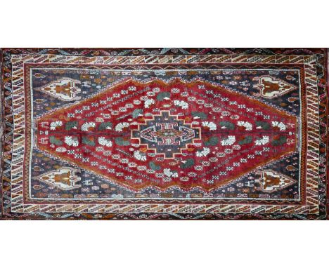 A South West Persian Qashqai carpet, central diamond medallion with repeating petal and animal motifs on a terracotta field w