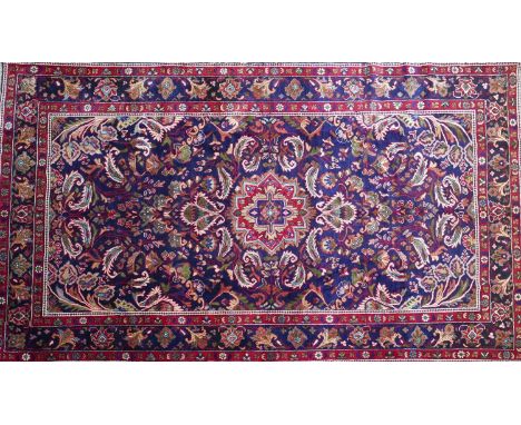 A Central Persian Bakhtiar carpet, central floral medallion with repeating spandrels on a sapphire field complimented by a st