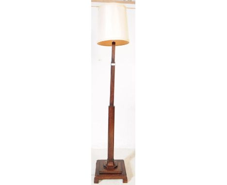 A 1930's Art Deco solid oak floor standard lamp. Raised on a terraced base with tapering column complete with the shade atop.