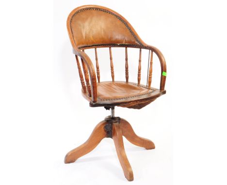 An early 20th century American oak and leather captains chair. The chair raised on splayed supports to base, with a swivel se