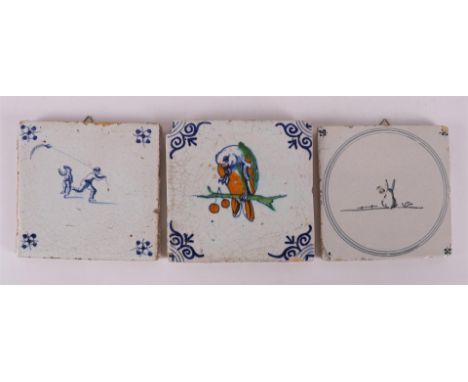 A polychrome tile with an image of a parrot on a branch, 17th century. The corners with ox head motifs, h 13 x w 13 cm (corne