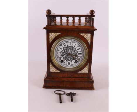 A table clock in oak housing with railing, 20th century, h 32 cm.