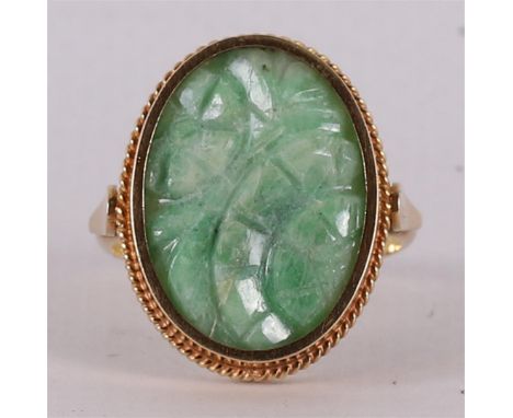 A 14 kt 585/1000 gold ring with a carved jade. Ring size Ø 18.25 mm.