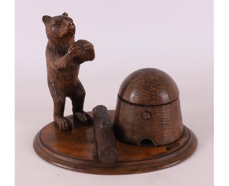 A carved wooden inkstand with bear by tree trunk, Germany, 19th century, h 12.5 x w 17 x d 12.5 cm (lid loose/damaged).