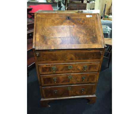 A small ladies' burr walnut three drawer bureau resting on bracket feet with herringbone inlay to top door and drawer fronts 