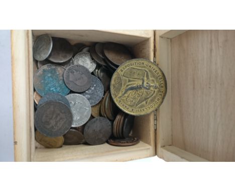 A box of coins together with a Paris 1867 Exhibition medal decorated with a side portrait of Napoleon III.