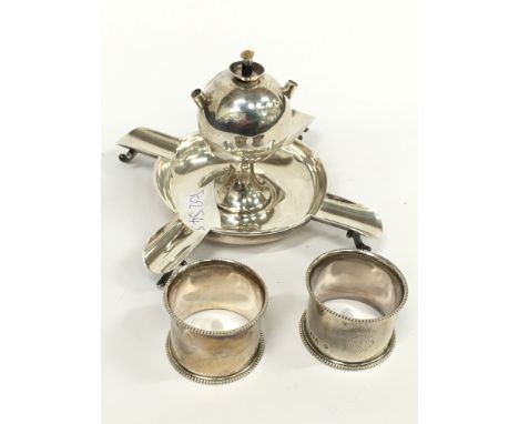 A Goldsmiths and Silversmiths silver table lighter and ashtray together with two silver serviette rings (171 grams overall).