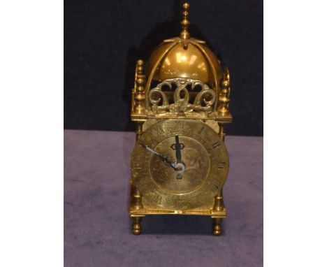 A miniature brass lantern style alarm clock