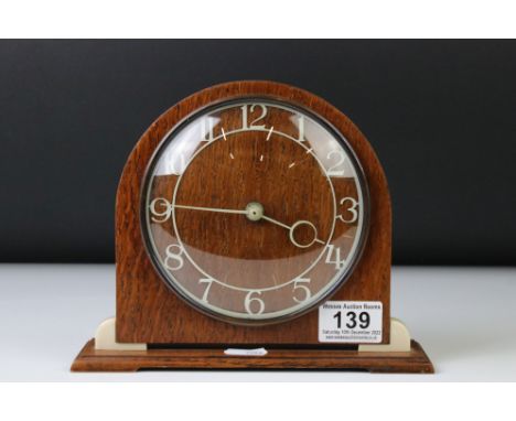 Art Deco style Smiths oak and Bakelite mantle clock of arched form, with cream Arabic numerals, convex dial window, raised on