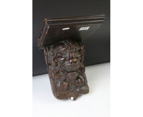 Antique carved oak wall bracket in the form of a lion mask, with square shelf, approx 28cm high 