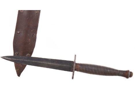 FAIRBAIRN-SYKES TYPE FIGHTING KNIFE MID-20TH CENTURY with tapered steel blade over cross guard and ribbed grip, leather scabb