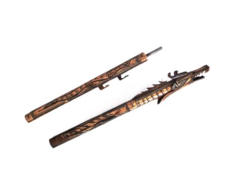 An early 20th Century Indonesian blow pipe dart. Bone construction carved into the shape a of a mythical dragon with ebonised