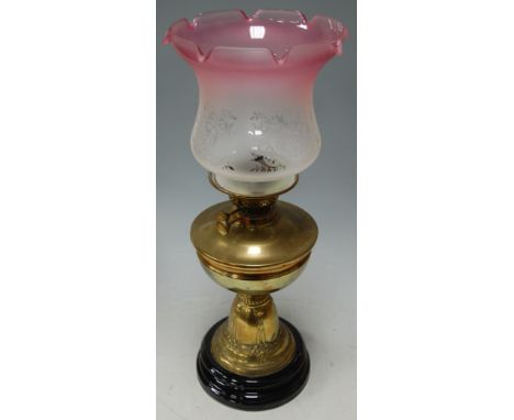 A Victorian brass pedestal oil lamp, having pink tinged etched glass shade