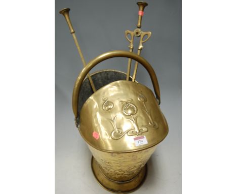 An Art Nouveau brass coal scuttle with turned brass fire tools