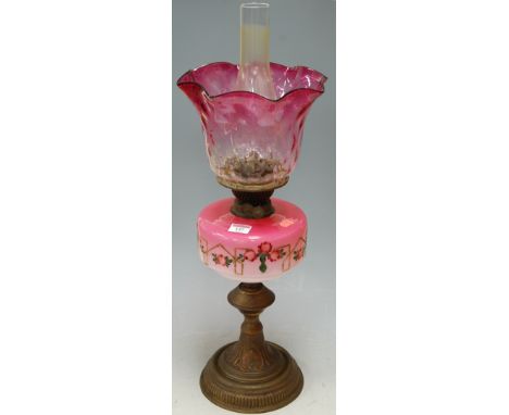 A Victorian brass pedestal oil lamp, having cranberry tinted glass shades and glass reservoir  Condition Report / Extra Infor
