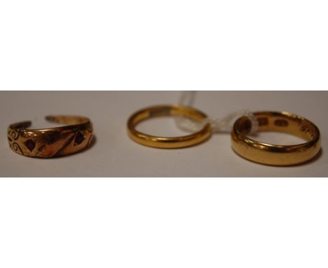 A 22ct gold wedding band, 3.7g; an 18ct gold wedding band, 5.1g; and one other yellow metal garnet set ring (cut) (3) 