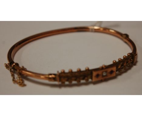 A childs 9ct seed pearl and ruby set bangle, 5.2g