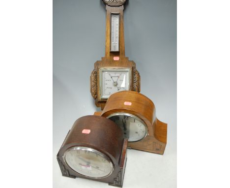 An early 20th century carved oak cased aneroid barometer; together with two 1920s mantel clocks (3)