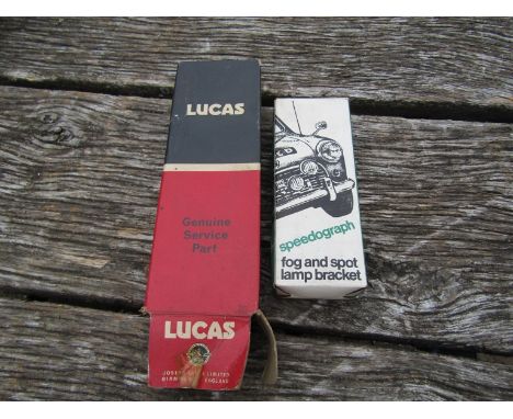 A boxed speedograph fog and spot bracket and a boxed Lucas lamp bracket 