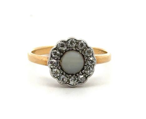 A foil backed white chalcedony and diamond cluster ring stamped 18ct, size J. Inscription to inner shank '28th Oct 1915'. 2.3