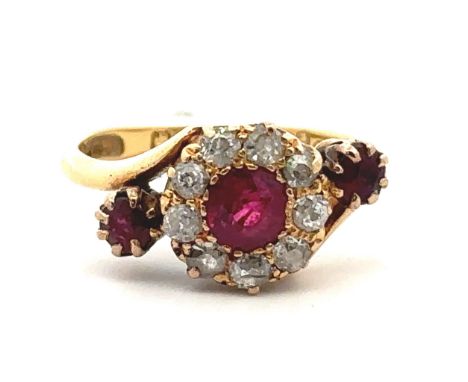 An unusual ruby and old cut diamond cluster ring in a crossover setting and flanked by a ruby on each side. Chester 1908 hall