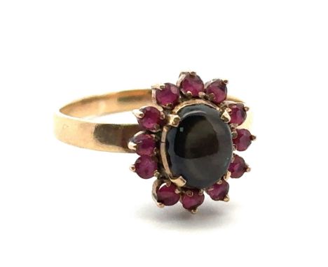 A gold sheen obsidian and ruby cluster ring, size P. Weight 3.13g. Obsidian approx 8mm x 6mm. Stamped 14K to inner shank. Sha