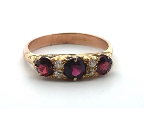 A garnet and diamond ring, size S in a yellow gold scroll mount with a rose gold shank. 4.85g.