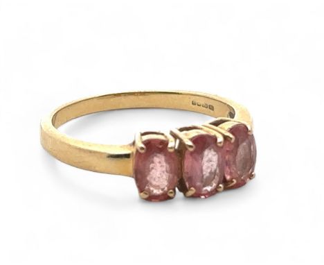 A three stone pink sapphire ring in 18ct yellow gold. Size N. Sapphires each 6mm x 4mm. Hallmarks for DK, Birmingham 2006. We