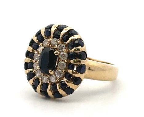 Sapphire and diamond cluster ring stamped 585, size O. Central sapphire approx 9mm x 3mm. Weight 5.6g. Ring head 17.5mm in le