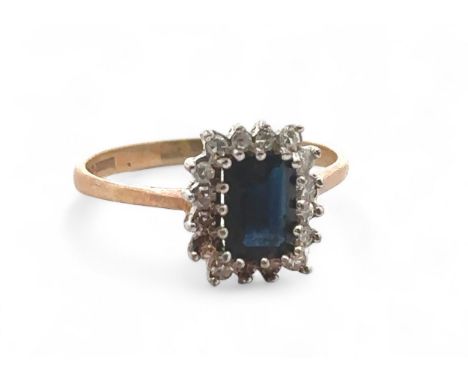 A sapphire and diamond cluster 9ct ring, size P. Sapphire 7mm x 5mm. Weight 2.2g. Condition - there is a build up of dirt/mat