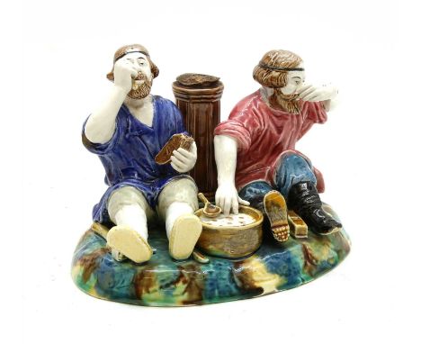 A Russian Kuznetsov porcelain figure, late 19th to early 20th century, depicting two peasants with tools, eating, with impres