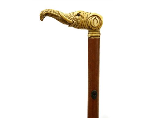 An ivory and malacca walking stick, 19th century, the elephant head handle above a plain tapering shaft with silver-mounted l