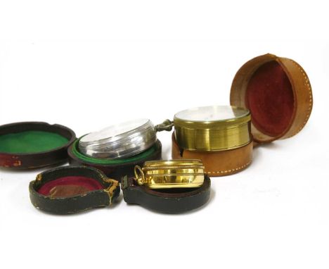 Three pocket barometers, the first in a brass case with a curved thermometer and a small star compass in the dial, 4.5cm diam