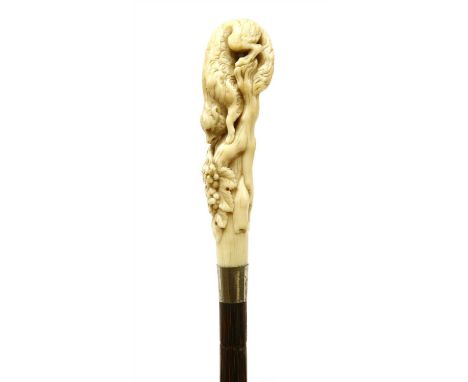 A carved ivory and partridgewood(?) walking stick, 19th century, the handle set with a fox among vines above a tapering shaft