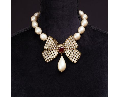 Chanel. Faux Pearls Collier mit großer Kristall-Schleife. Um 1970/80. Metall, goldfarben, perlmuttfarbene Glasperlen, farblos