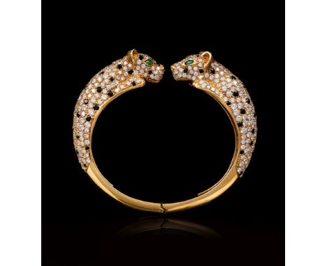 Exzellenter Panther-Armreif mit Brillanten und Smaragd-Augen. 18 kt. GG. Armspange mit zwei schauseitigen Panther-Köpfen, rei