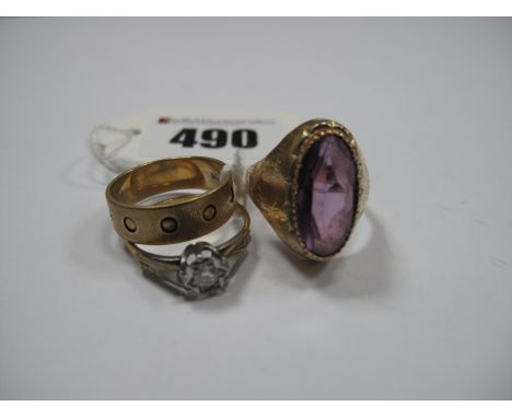 A 9ct Gold Band, a stone set ring, oval collet set, indistinctly stamped and another ring, illusion set between textured shou